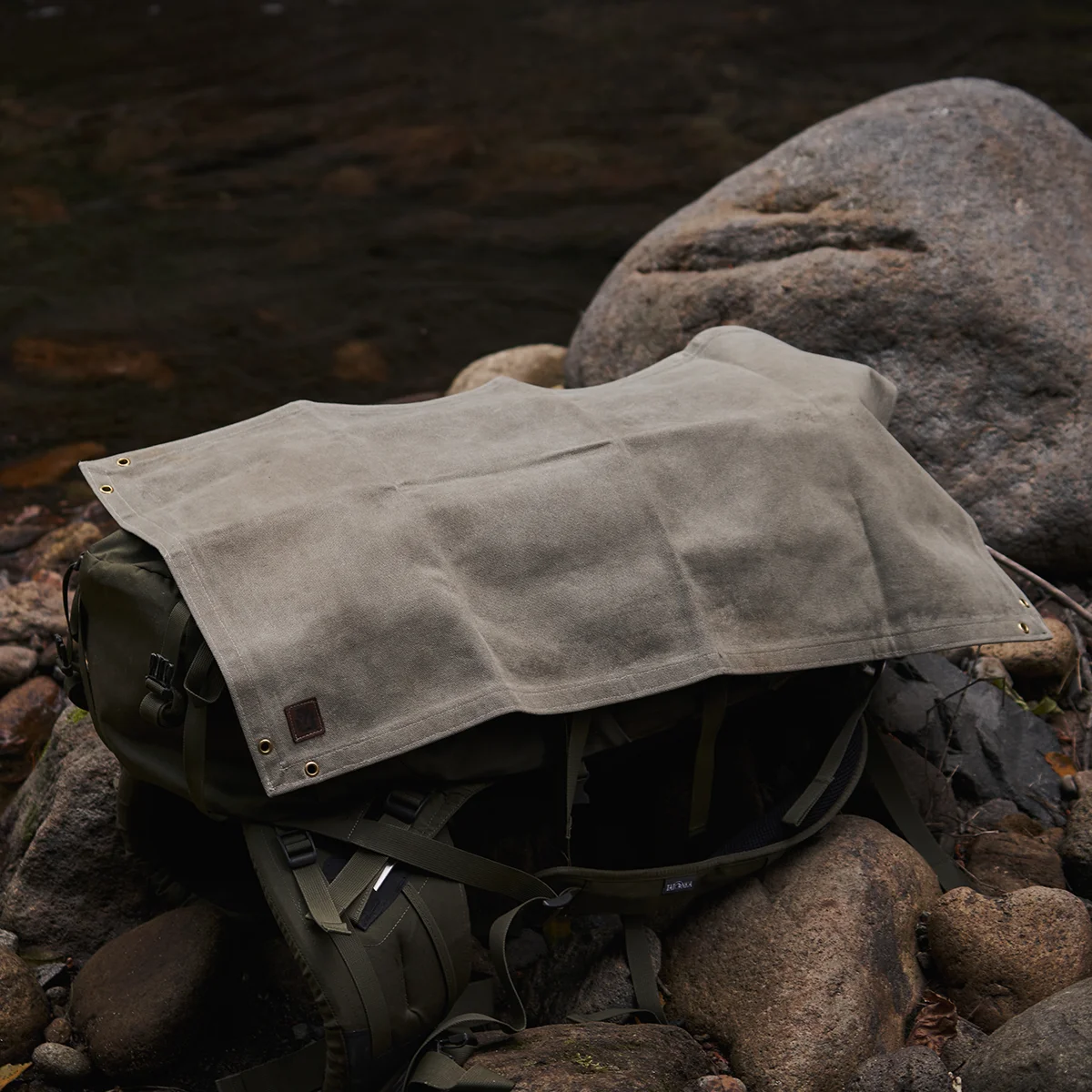 Waxed canvas mat spread over hiking pack